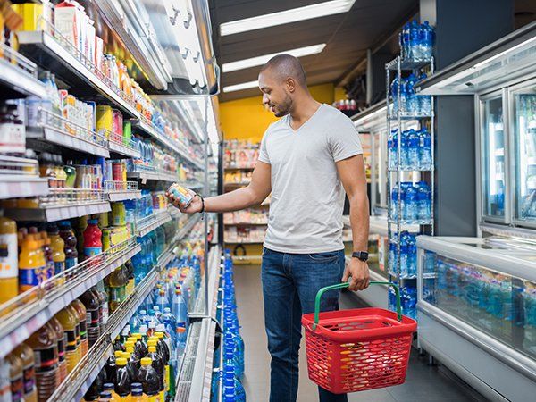 a man holding a shopping bucket and some drink