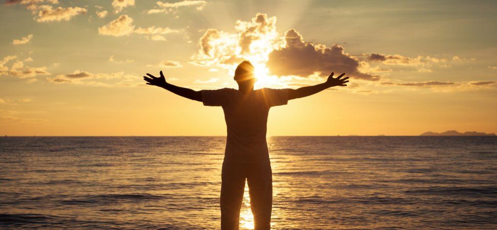 a man standing on the beach with hands open