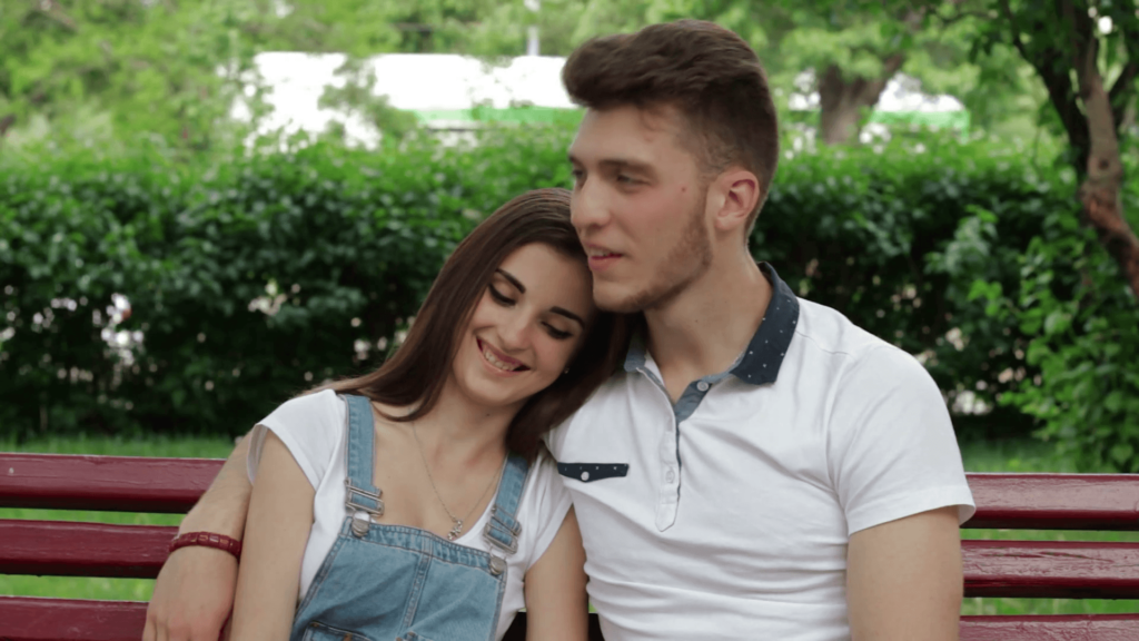 a couple sitting on a bench in the park