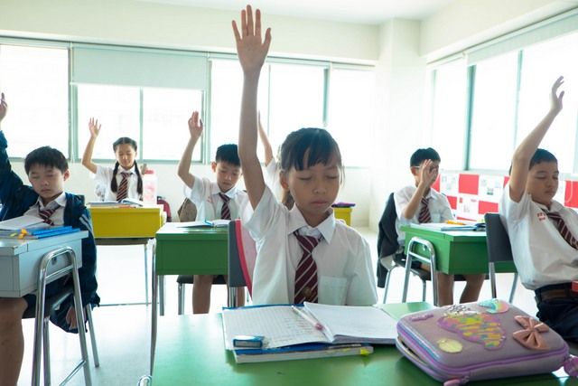 students with eyes closed fearing detained list sitting in a classroom