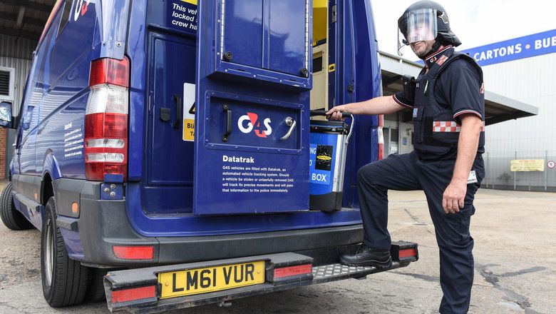 a security guard standing in front of a money van