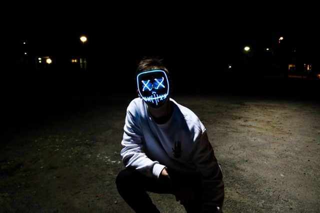 a man sitting on knees with a mask