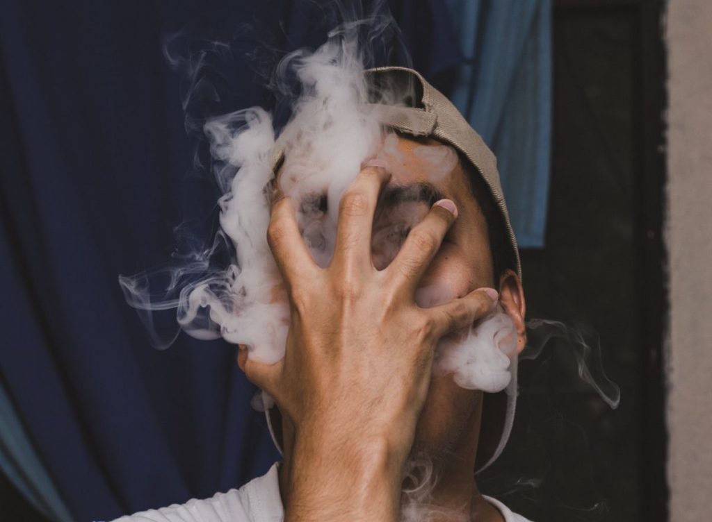 a man smoking weed with covered face showing the bad effect of drugs and credit cards.