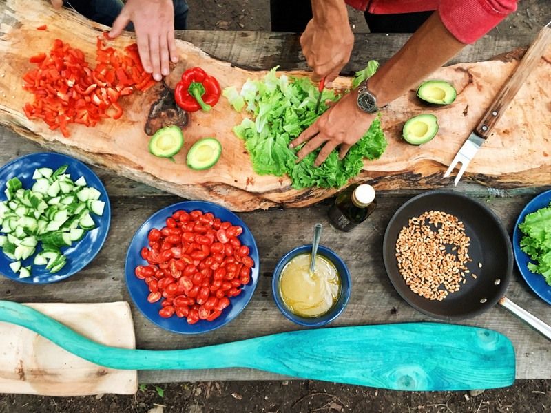 a slicing table with a lot of vegetables and fruits on it