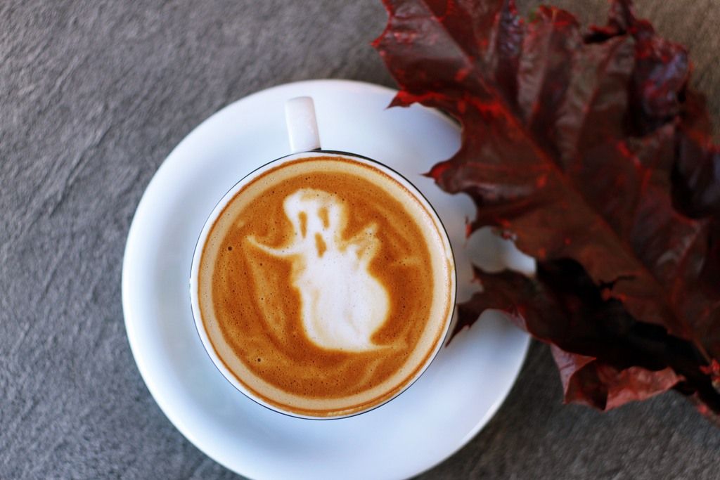 A Coffee Mug Depicting A Ghost In The Brown Cappuccino